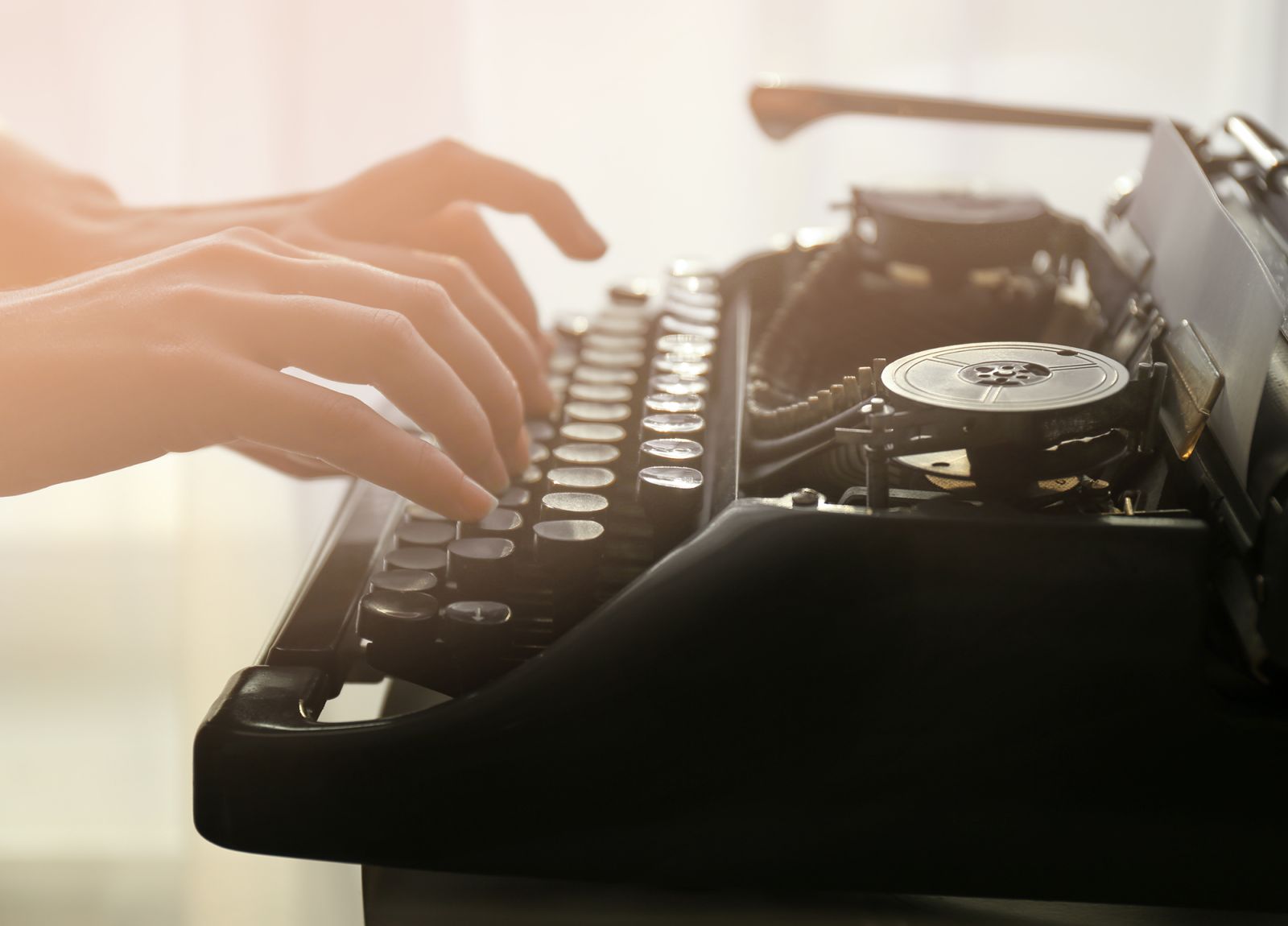 woman's hands writing on a typewriter