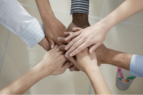 several hands clasped together in unity