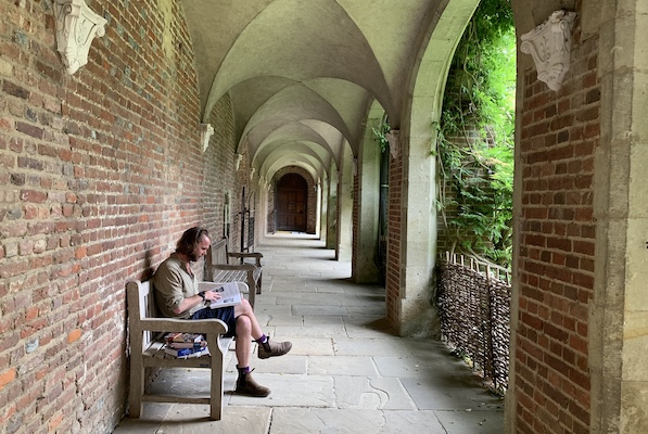 a person reading in cloisters