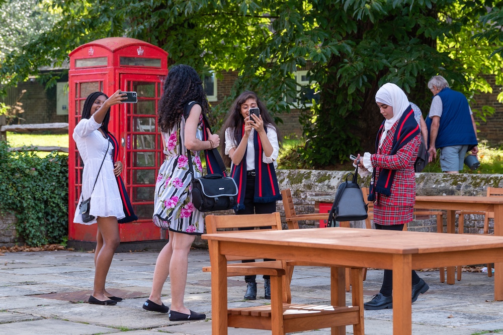 people gathering in front of an old-fashioned red telephone box
