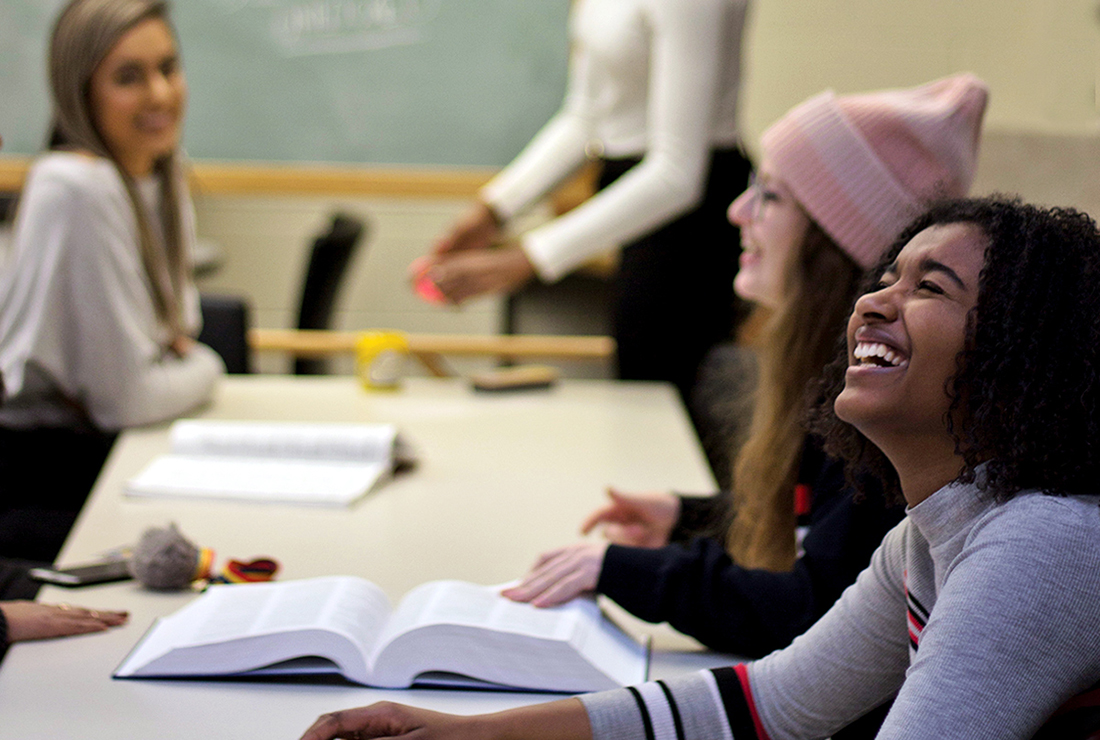 Students in a study room smiling and laughing