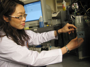 woman putting lab sample into machine