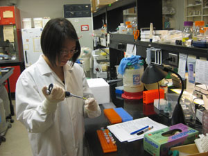 female student working with cancer test tubes in a lab