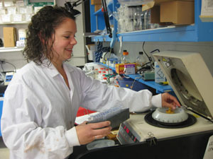 female students putting samples into lab cetrifuge