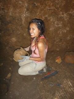 Photograph of a student holding an intact vessel that she has discovered at the Caere excavation site.