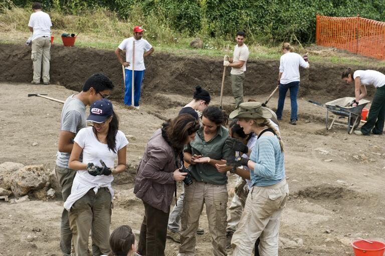 Students sharing finds from Caere dig with Dr. Cristiana Zaccagnino on site.