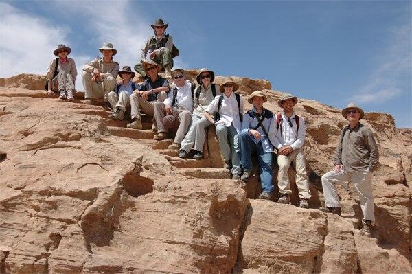 Group shot of Humayma excavation team amidst desert rocks.