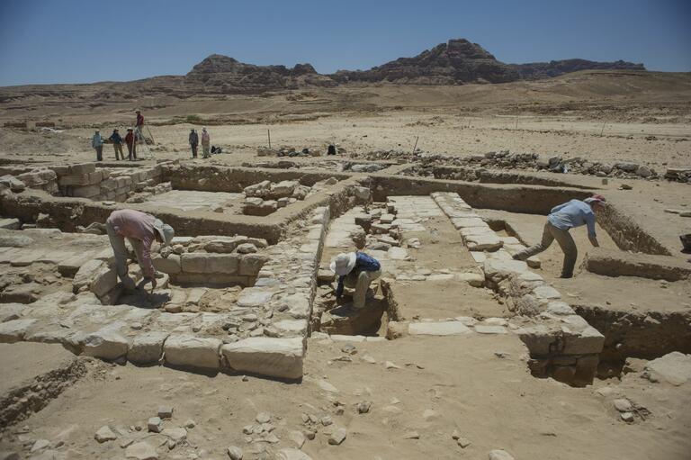 Students doing careful brushing of wall stones at Humayma excavation site.