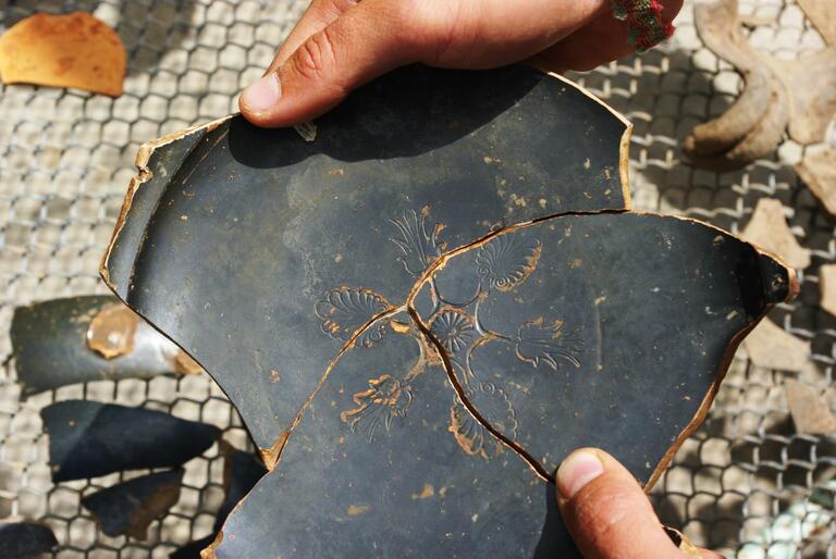 Broken pottery sherds pieced together.