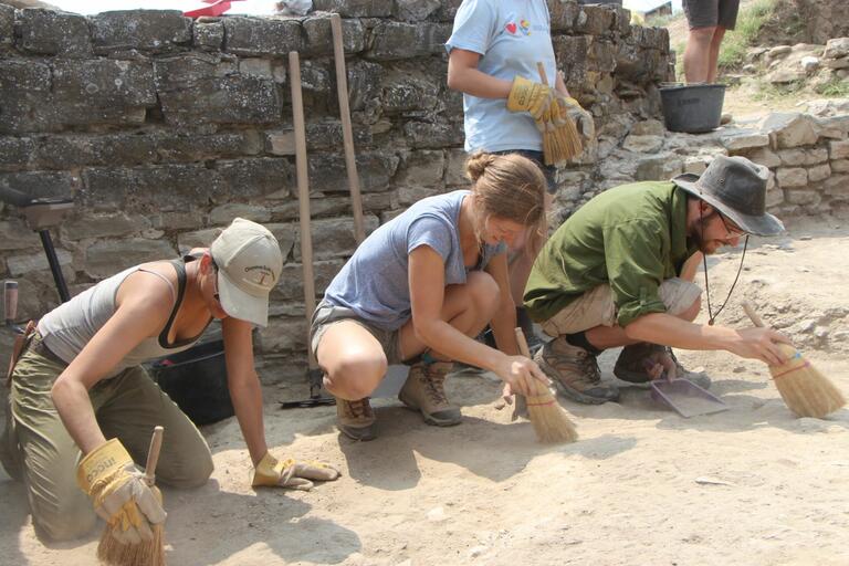 Students carefully sweeping during Stobi excavation.