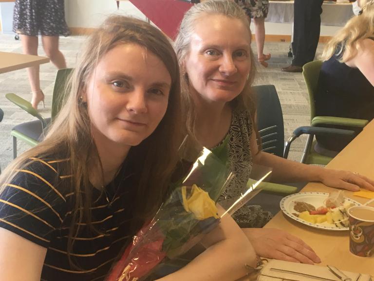 A graduate with a family member smiling