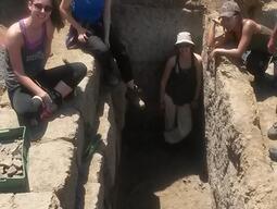 Students posing in and around a trench on the Caere dig site in 2016.