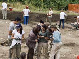 Students sharing finds from Caere dig with Dr. Cristiana Zaccagnino on site.