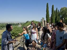 Dr. Fabio Colivicchi talking to students on a walkway overlooking a valley in Italy.