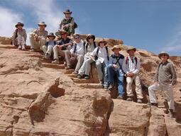 Group shot of Humayma excavation team amidst desert rocks.