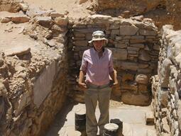 Student posing in a cleared room at Humayma excavation site.