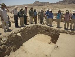 Students and Dr. Reeves gathered around examining a trench at Humayma dig site.