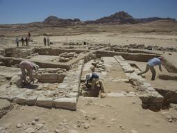 Students doing careful brushing of wall stones at Humayma excavation site.