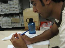 Student learning how to re-attach pieces of pottery during Matera field study.