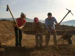 Dr. Colivicchi and two students digging with pick axes at Matera excavation site.