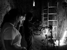 Black and white photo of students setting up to take photographs of underground chambers at Stobi.