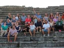 Group shot of Stobi excavation group posing on some stone steps.