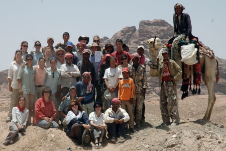 The 2010 Humayma Excavation team (and a camel) onsite, with rock formations in the background.