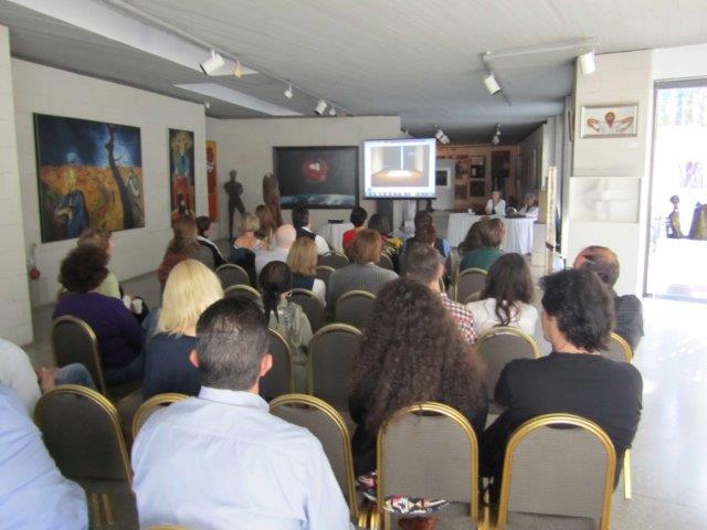 People sitting in chairs watching a presentation