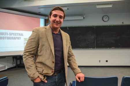 A person leaning on a podium smiling