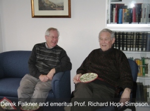 Two people seated laughing, one has a plate of food