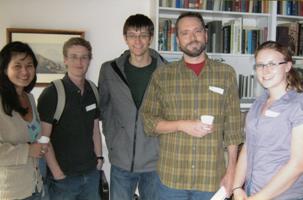 Five people standing and smiling