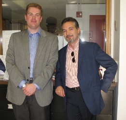 Two people in suits standing and smiling