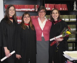 Three graduates with a faculty member