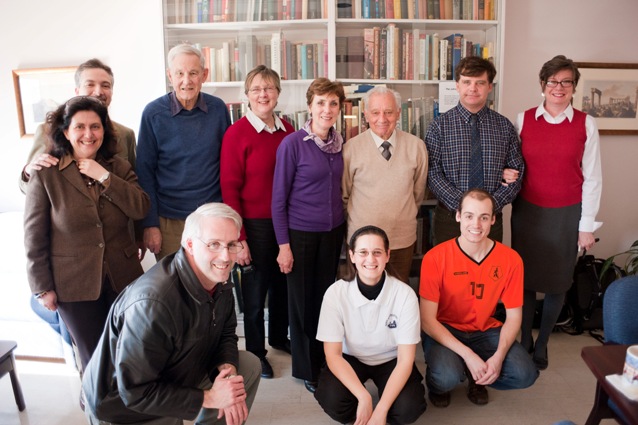 A group of people smiling in front of a bookshelf