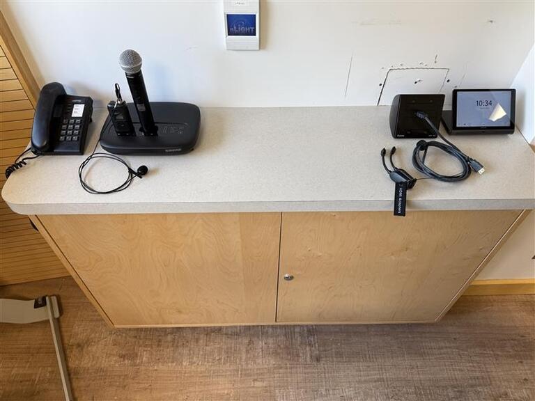 The small podium is equipped with a set of cords to present media in the room.