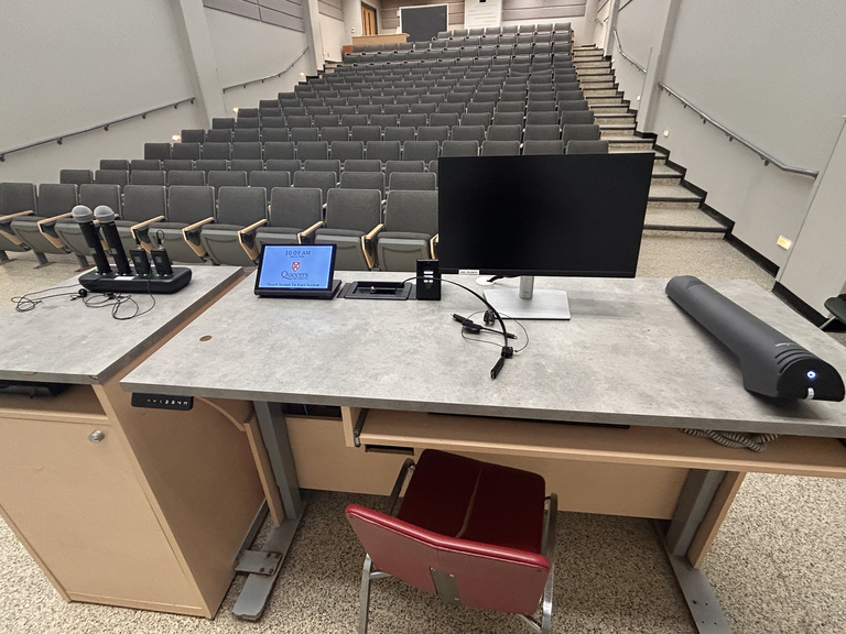 Top-down view of podium. Microphones on the left; touch panel control system and PC at center; document camera on the right.