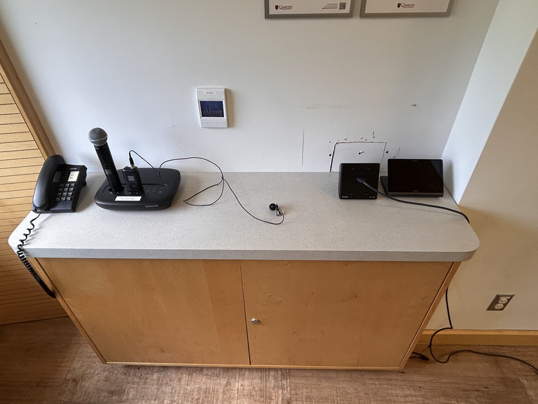 Top-down view of podium. Telephone and microphones on the left; touch panel control system on the right.