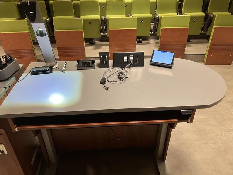Top down view of the podium. This podium is equipped with a set of microphones, a document camera, lecture capture and wireless presentation. The podium is height adjustable. 