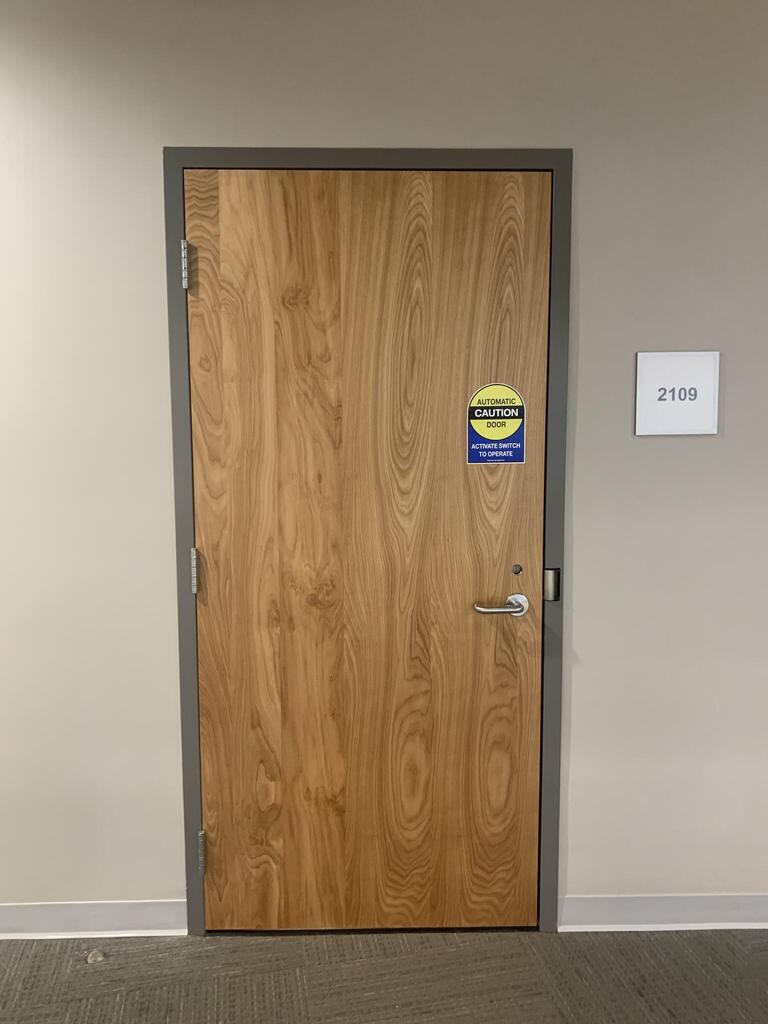 Entryway door to Biosciences complex, room 2109. The door has a handle on the right side.