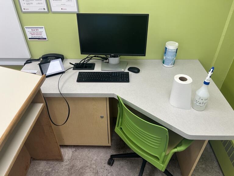 Image of the podium at the front of the classroom. This podium is not movable or height adjustable. A phone is located on the left side of the podium. This podium is not accessible