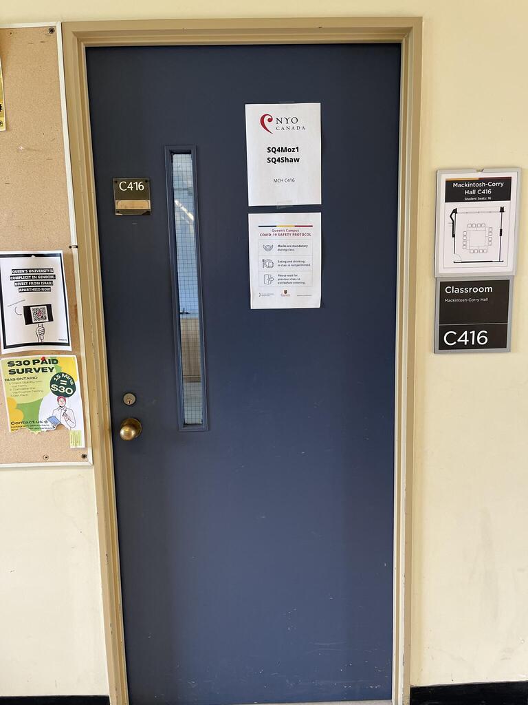 The entryway of room C416 in Mackintosh Corry Hall is a blue door with a doorknob on the left side.