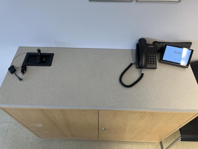Top-down view of the podium, equipped with a set of connection cables to present media in the room.