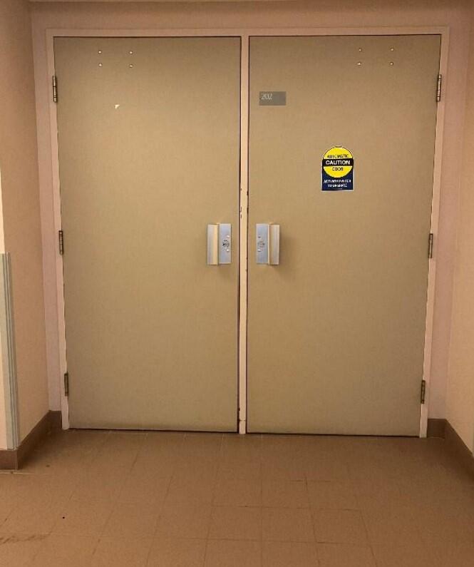 The entryway of room 202 in Robert Sutherland Hall is a pair of white doors with handles in the middle of the double doors.