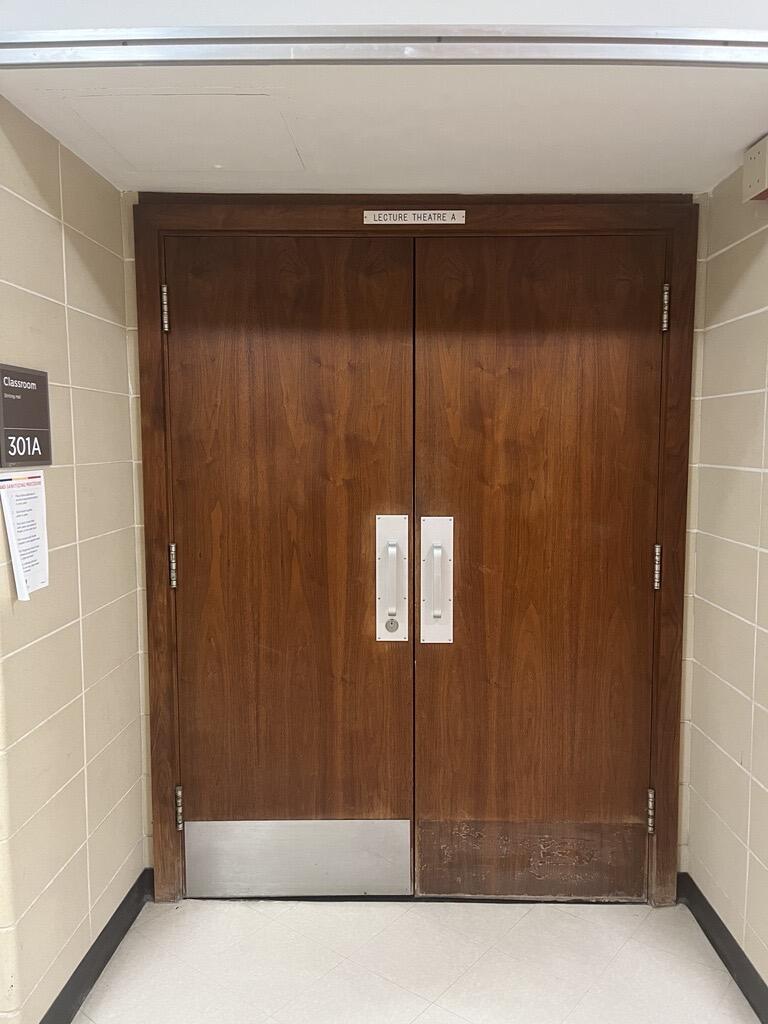 The entryway of room 301A in Stirling Hall is a double door with two pull handles in the center. The door does not have an automatic operator.