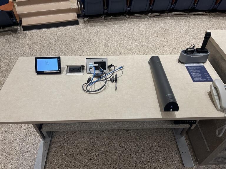 Top down view of the podium. The podium is height adjustable and comes equipped with lecture capture, a document camera as well as a set of microphones.
