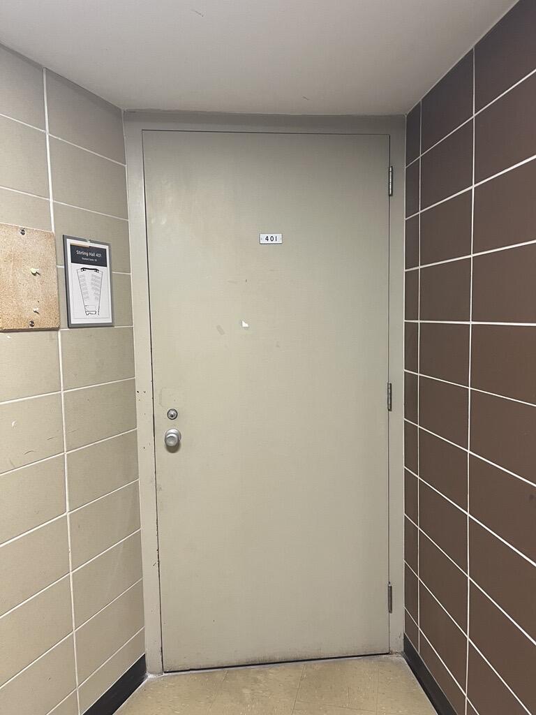 Entryway to room 401 in Stirling Hall. The door has a knob on the left side. There is no automatic operator.