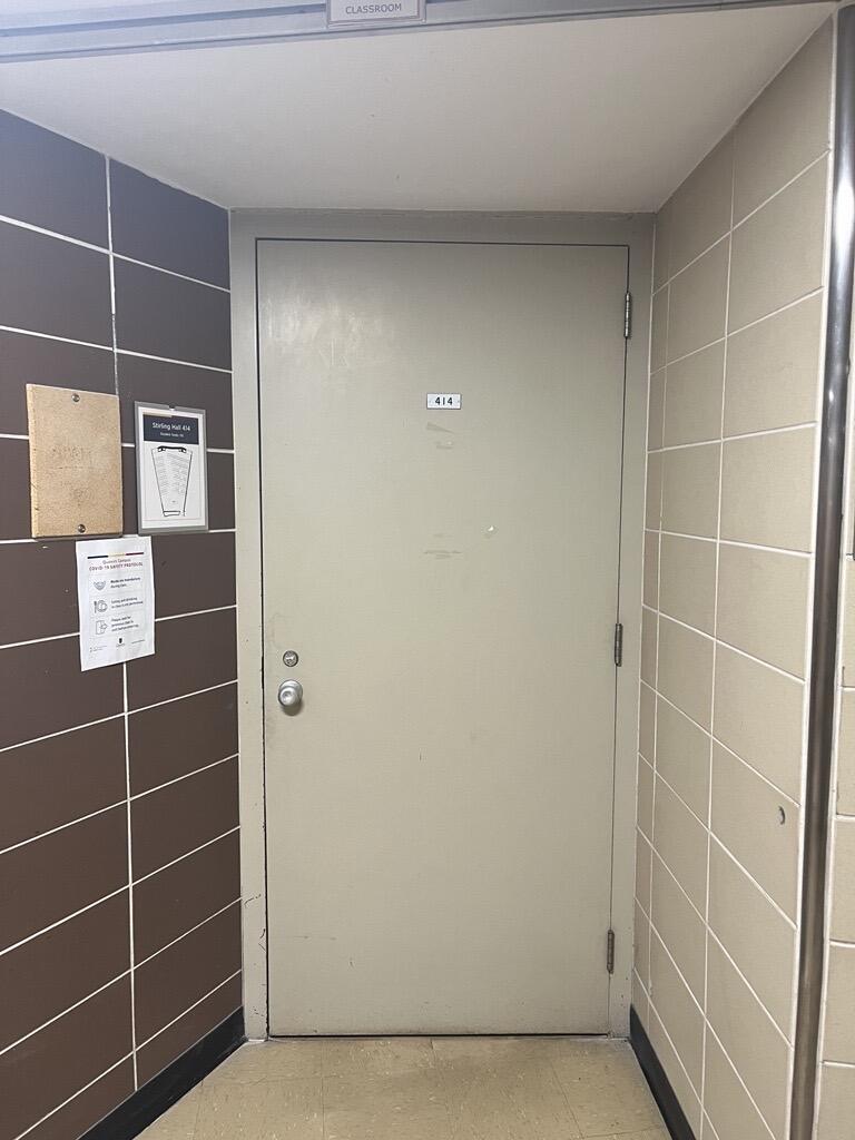 Entryway to room 414 in Stirling Hall. The door has a knob on the left side. There is no automatic operator.