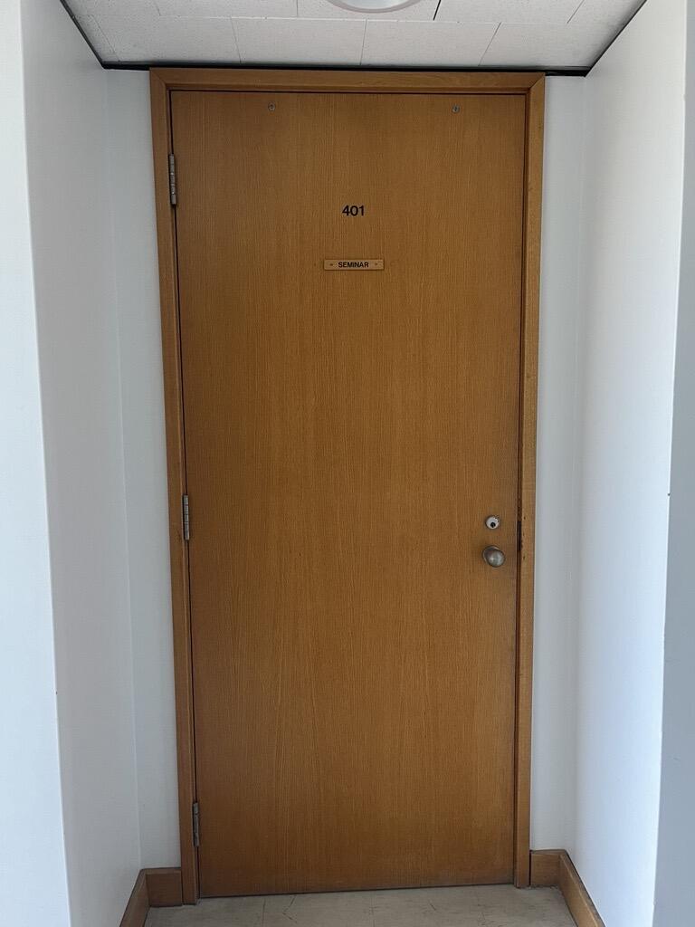 The entryway of room 401 in Watson Hall is a wooden door with a doorknob on the right side.