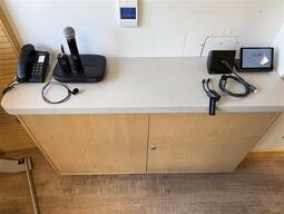 The small podium is equipped with a set of cords to present media in the room.