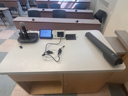 Top-down view of podium. Microphones on the left; touch panel control system at center; document camera on the right.
